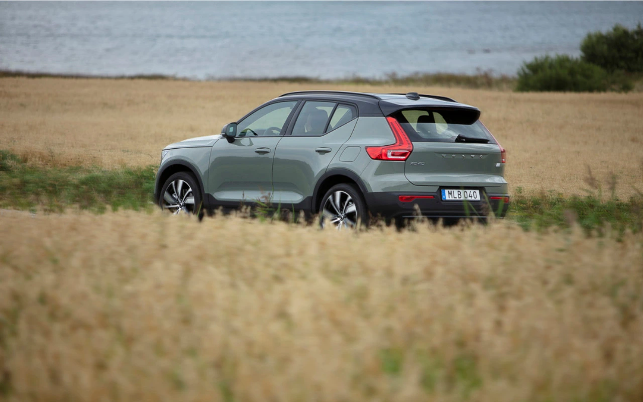 vue latérale arrière d'une Volvo XC40 2022 sur une route qui traverse un champ