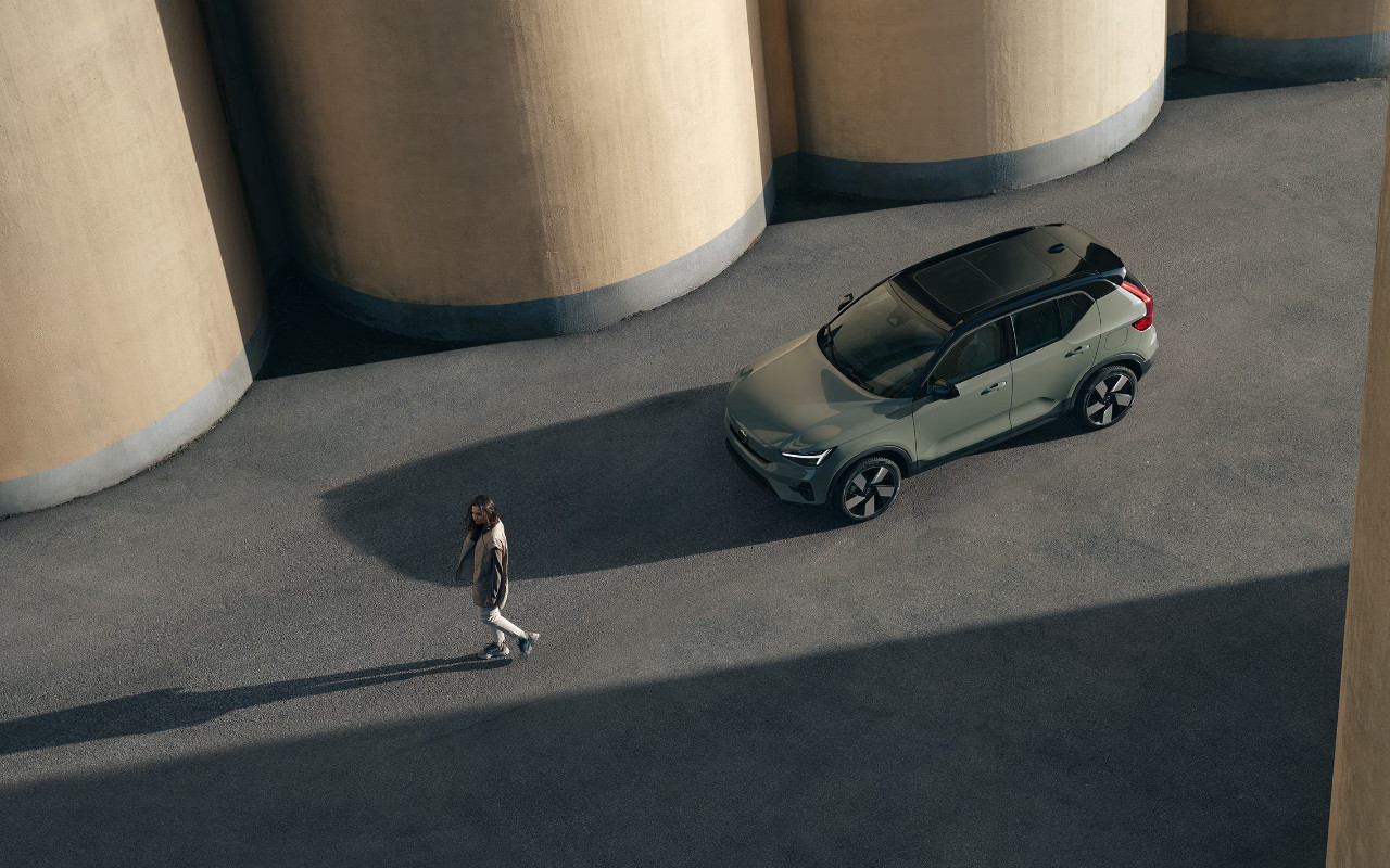 vue latérale avant d'une Volvo XC40 recharge près de son conducteur