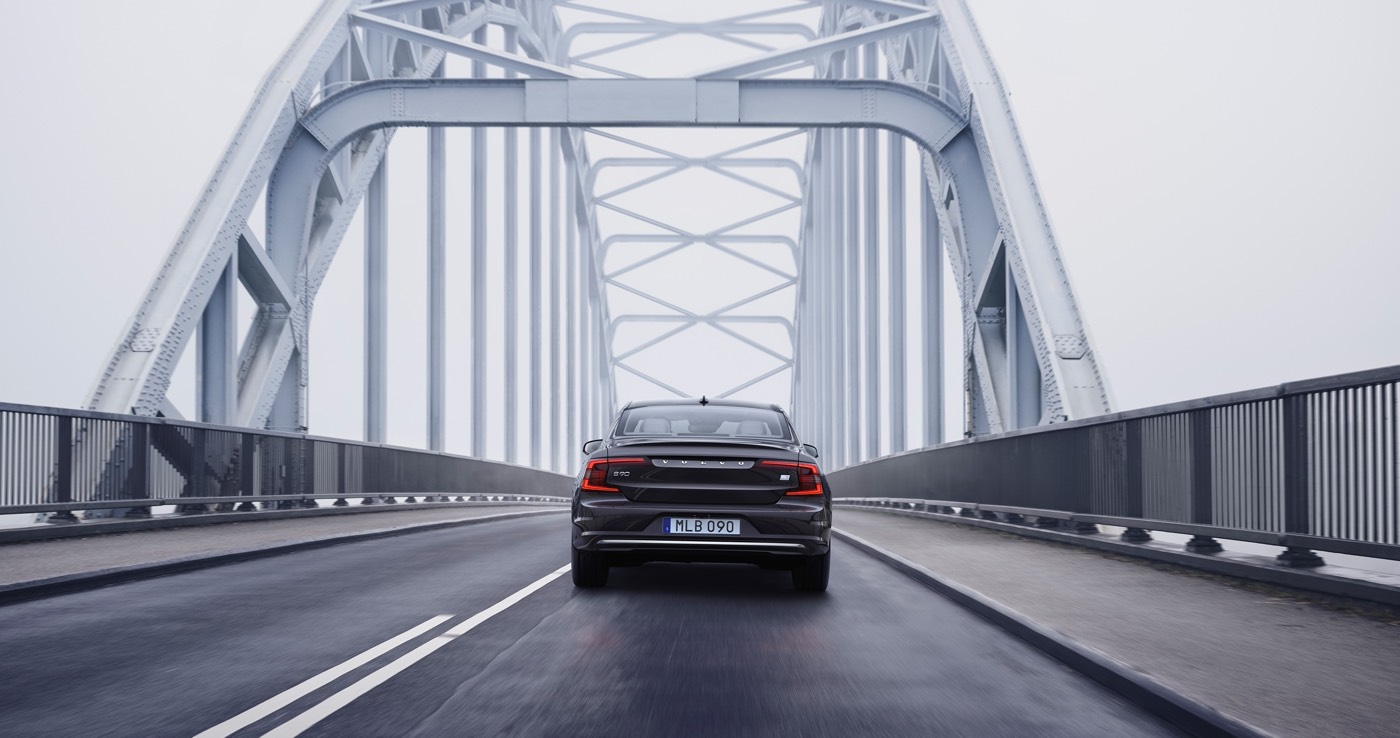 Vue arrière du Volvo S90 Recharge T8 plug-in hybrid traversant un pont