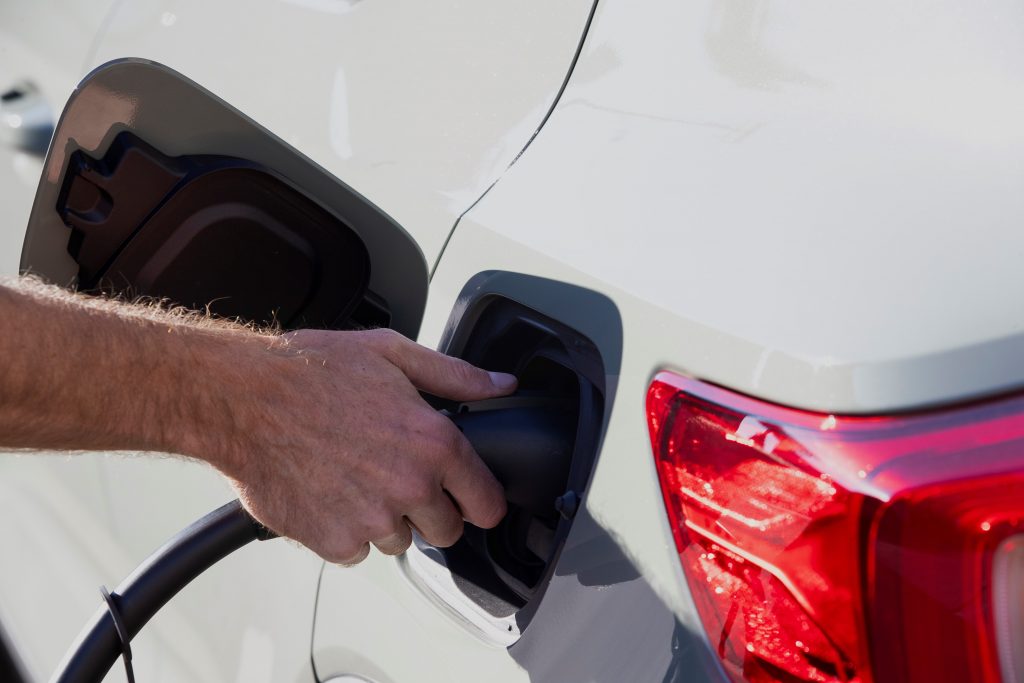 Une personne connecte le chargeur dans la prise électrique du Volvo XC40 2022 Recharge